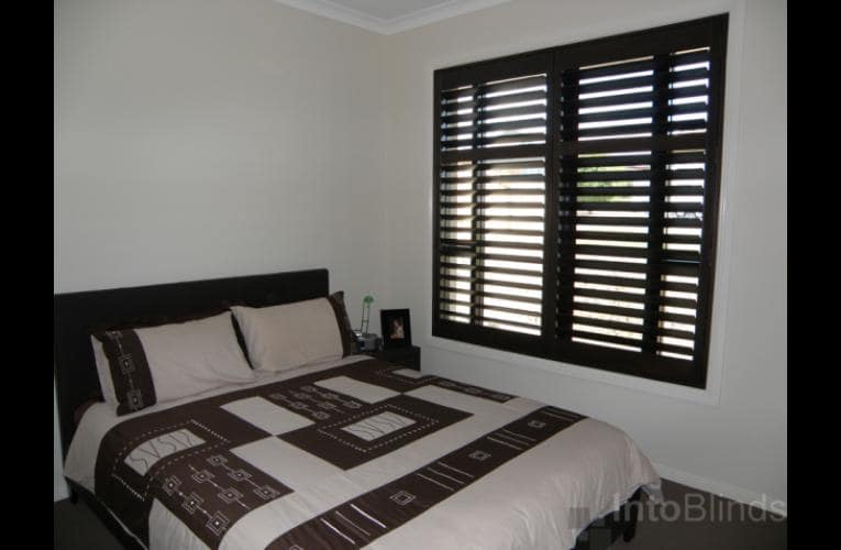 Dark Stained Timber Plantation Shutters installed on bedroom windows