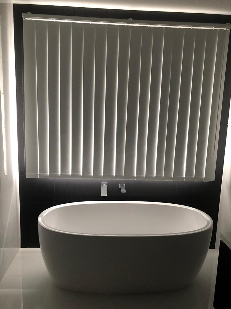 Bathroom with Blockout Vertical Blinds slightly open allowing filtered light to enter