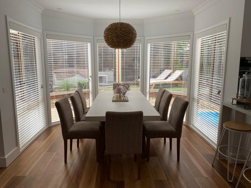 Bay window in dining room with white pvc venetian blinds