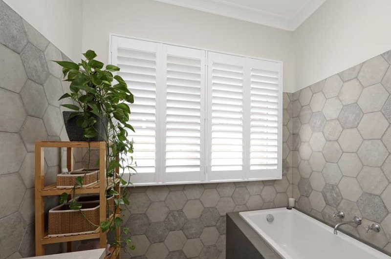 White PVC Plantation Shutters mounted on bathroom window slats open grey tiles and white ceiling Hawthorn North